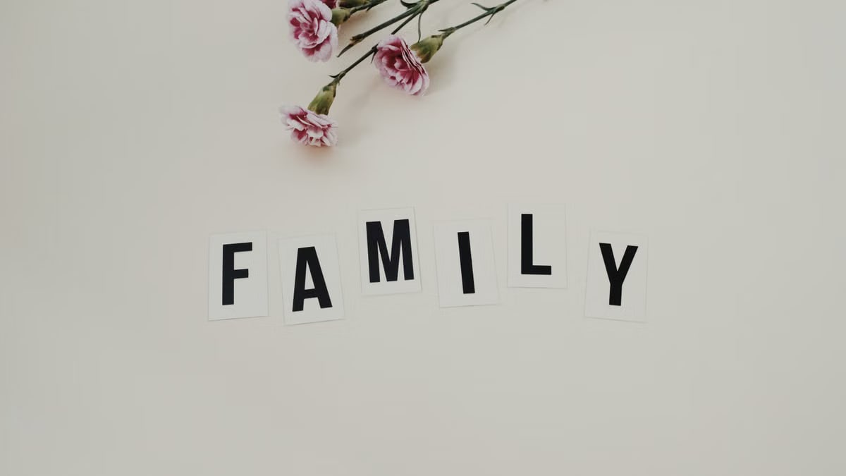 Elegant arrangement of pink flowers and family text on a white background, ideal for family themes.
